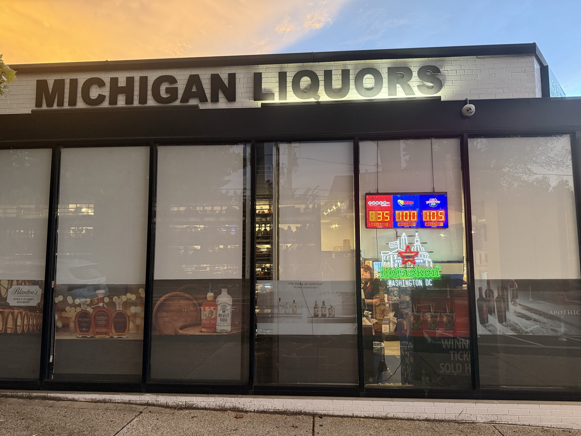 Michigan Liquors at dusk — the lit storefront sign on 12th Street NE, Washington DC